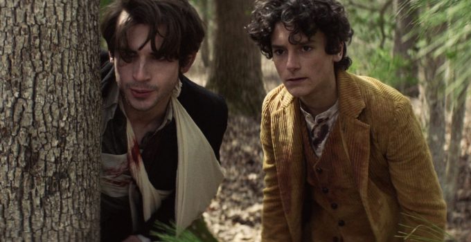 Elton e Percy se escondendo atrás de uma árvore enquanto fogem de alguém no episódio 3 da 2ª temporada de The Walking Dead: World Beyond.