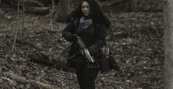 Iris segurando sua crossbow na floresta no episódio 1 da 2ª temporada de The Walking Dead: World Beyond.